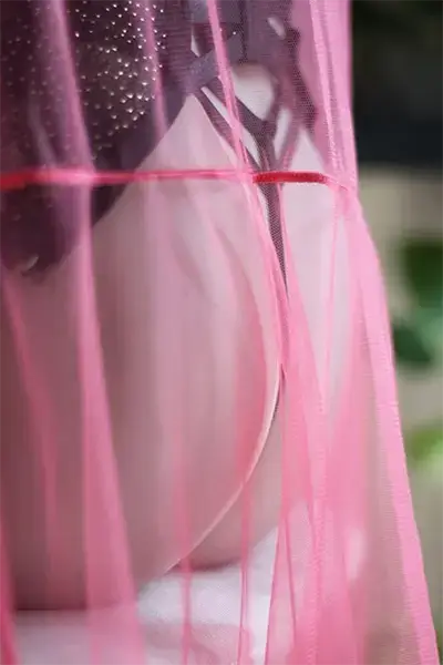 Jeu de transparence d’un voile rose sur une poupée 4Woods Europe.